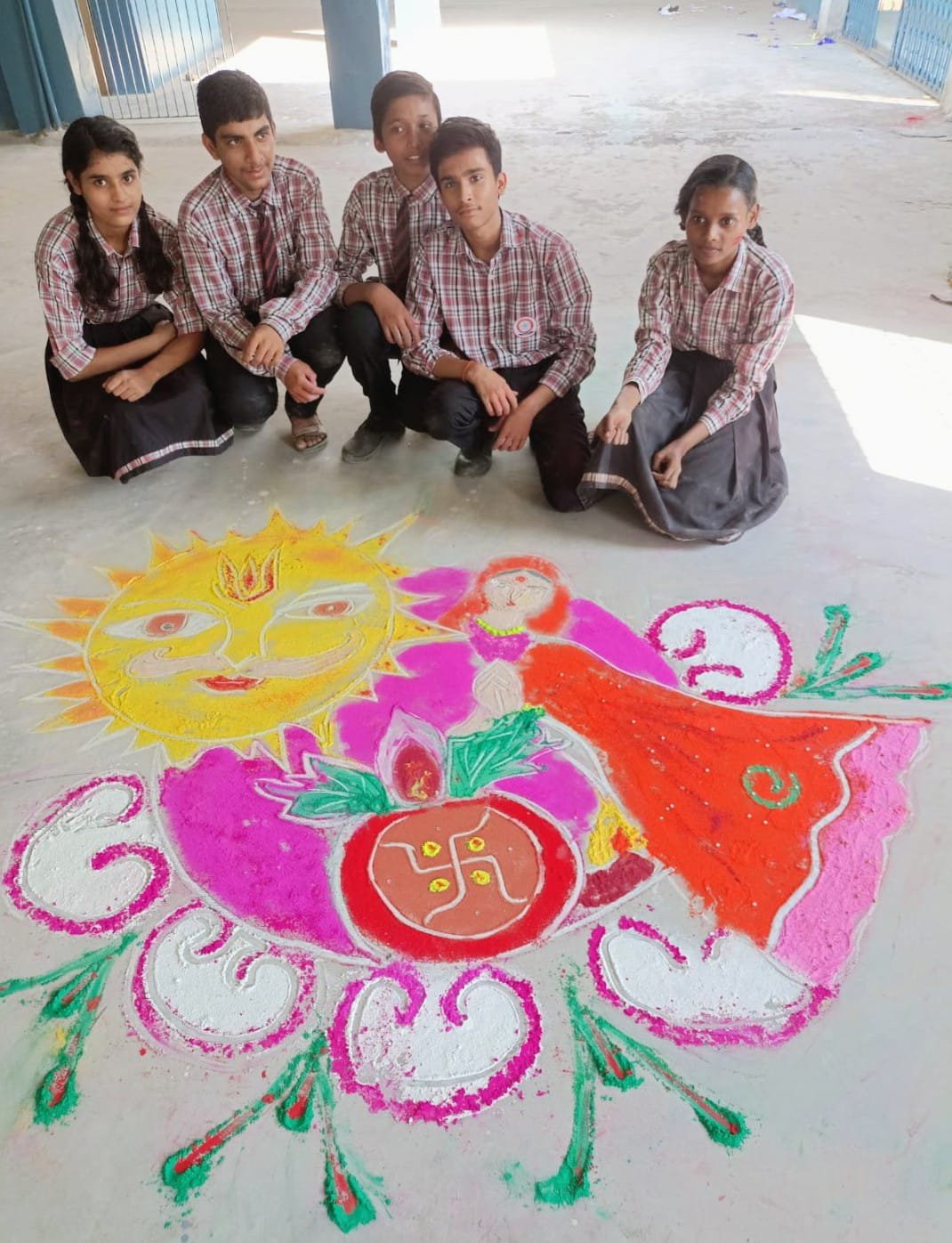 Students posing with colorful Diwali rangoli