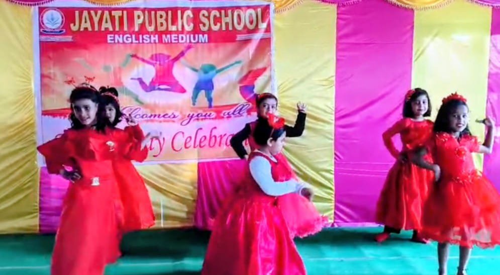 Girls in red performing group dance on stage