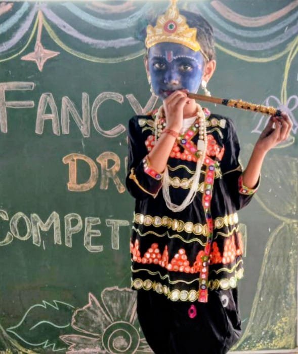 Child dressed as Lord Krishna playing flute